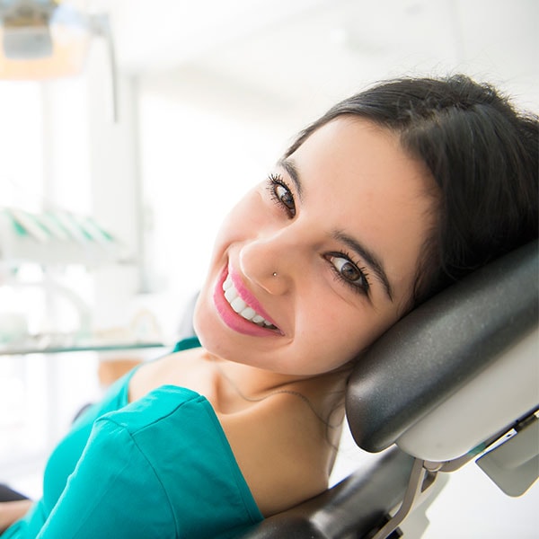 A young woman reclining in a dental chair