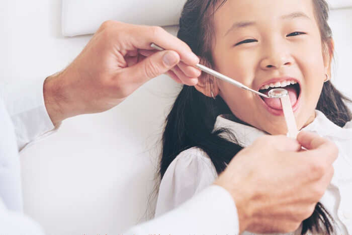 A dentist examining a young girls mouth
